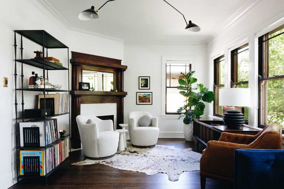 Exempel på ett klassiskt separat vardagsrum, med ett bibliotek, vita väggar, mörkt trägolv, en standard öppen spis och brunt golv