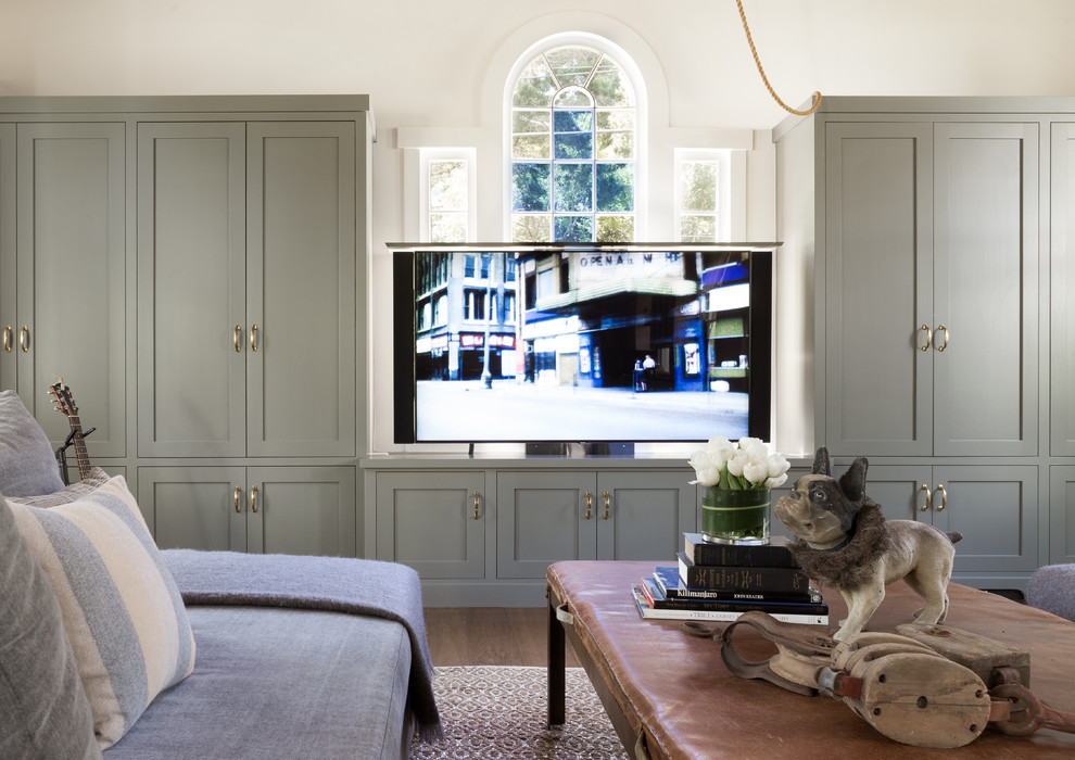 Klassisk inredning av ett allrum med öppen planlösning, med vita väggar, mellanmörkt trägolv och en dold TV