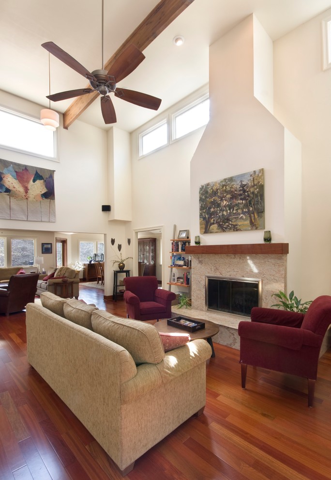 Mittelgroßes, Offenes, Fernseherloses Modernes Wohnzimmer mit beiger Wandfarbe, dunklem Holzboden, Kamin und Kaminumrandung aus Stein in New Orleans