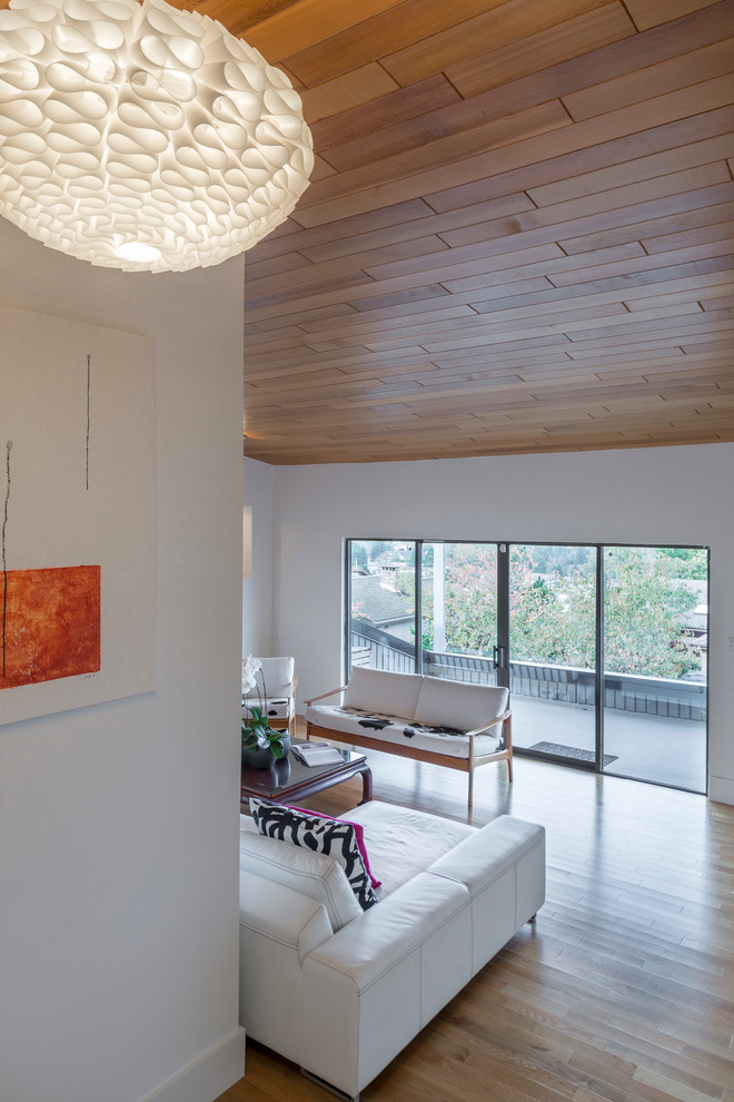 Mittelgroßes, Fernseherloses, Offenes Modernes Wohnzimmer mit weißer Wandfarbe, hellem Holzboden, Gaskamin und verputzter Kaminumrandung in Vancouver