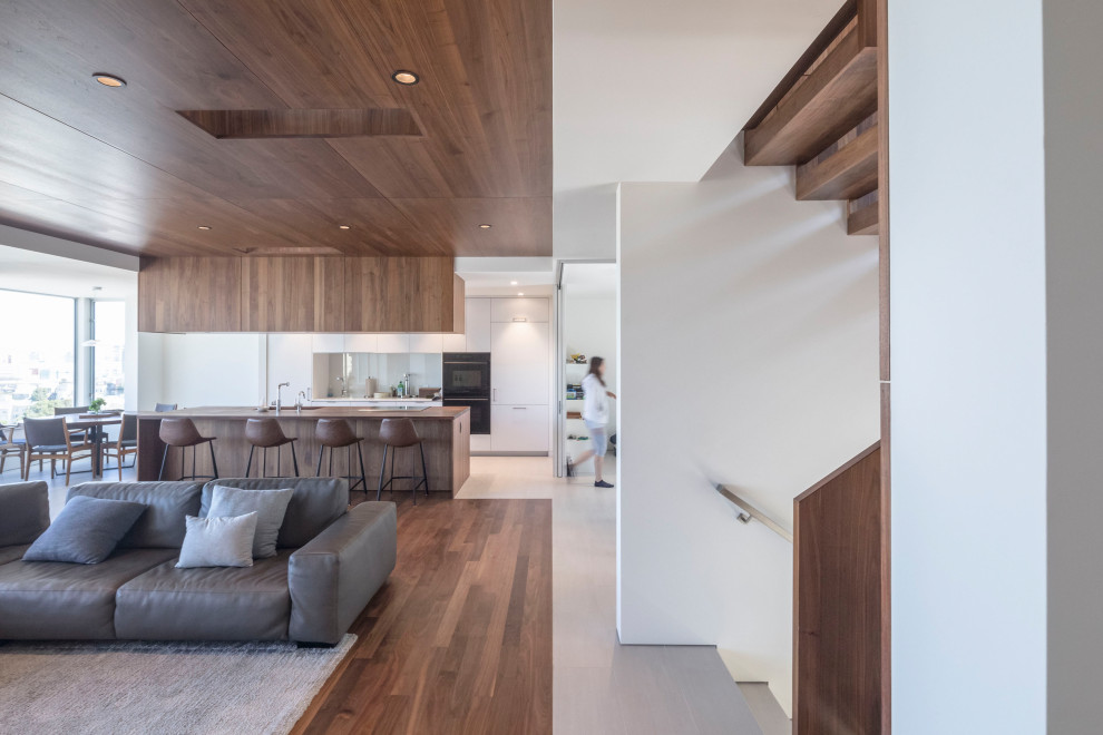Idées déco pour un salon moderne ouvert avec un sol en bois brun et un sol marron.