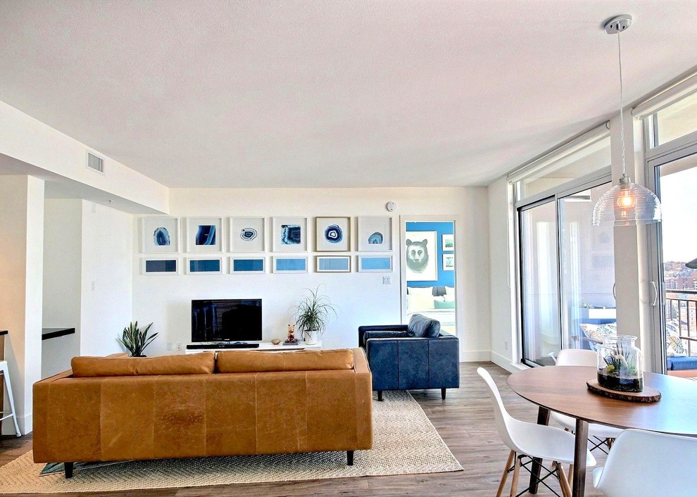 Foto di un grande soggiorno minimalista aperto con sala formale, pareti bianche, pavimento in vinile, TV autoportante e pavimento marrone