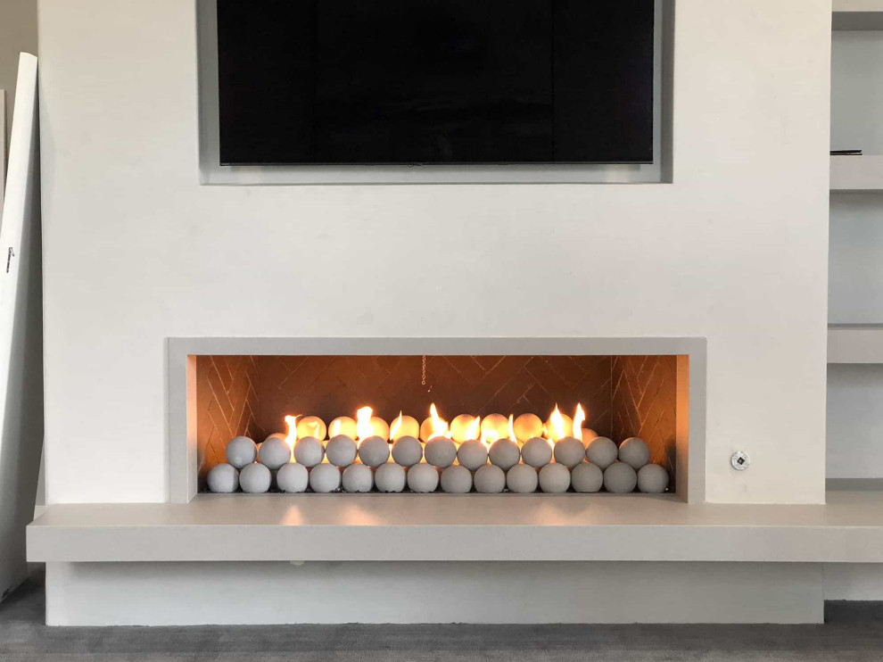 Example of a large danish open concept light wood floor and gray floor living room design in San Diego with white walls, a standard fireplace, a stone fireplace and a media wall