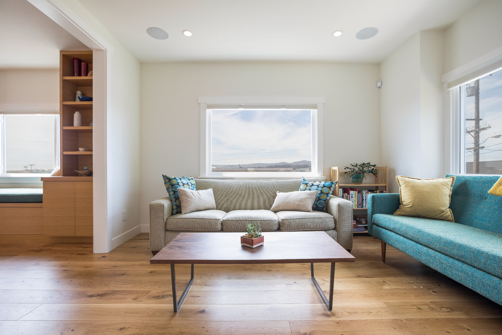Immagine di un soggiorno minimalista di medie dimensioni e aperto con pareti bianche, pavimento in legno massello medio, TV a parete, pavimento marrone e sala formale