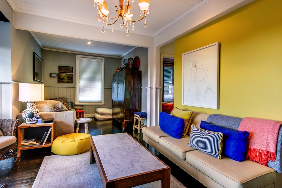 Photo of a medium sized eclectic open plan living room in Melbourne with yellow walls and dark hardwood flooring.