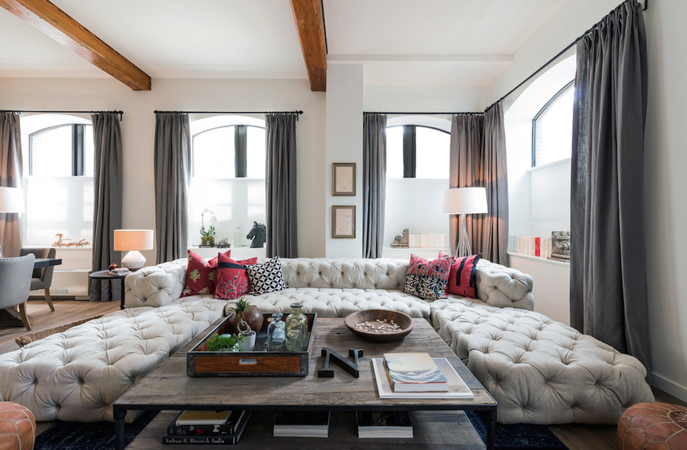 Esempio di un soggiorno design aperto con pareti beige e pavimento in legno massello medio