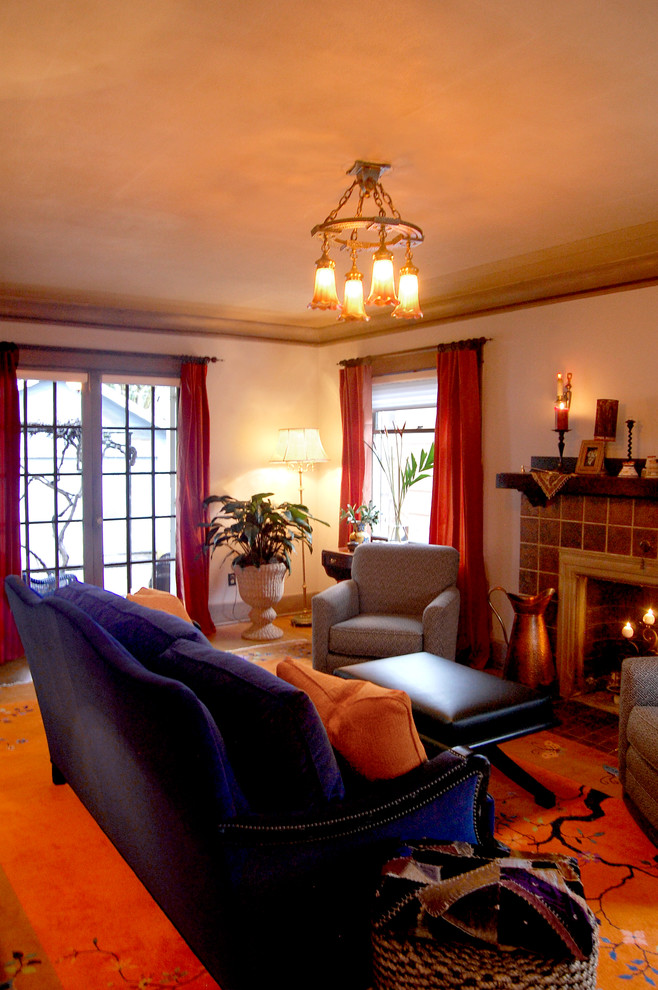 Inspiration pour un petit salon bohème fermé avec un mur gris, un sol en bois brun, une cheminée standard et un manteau de cheminée en carrelage.