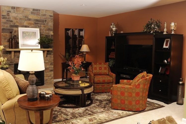 На фото: гостиная комната в стиле неоклассика (современная классика) с оранжевыми стенами, ковровым покрытием, стандартным камином и фасадом камина из камня с