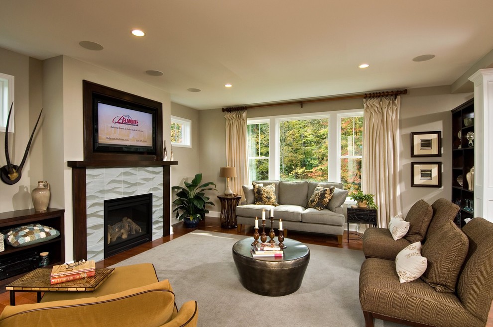 На фото: изолированная гостиная комната в современном стиле с стандартным камином и телевизором на стене с