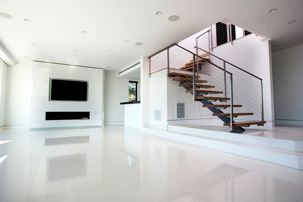 Großes, Offenes, Repräsentatives Modernes Wohnzimmer mit weißer Wandfarbe, Porzellan-Bodenfliesen, TV-Wand und weißem Boden in Los Angeles