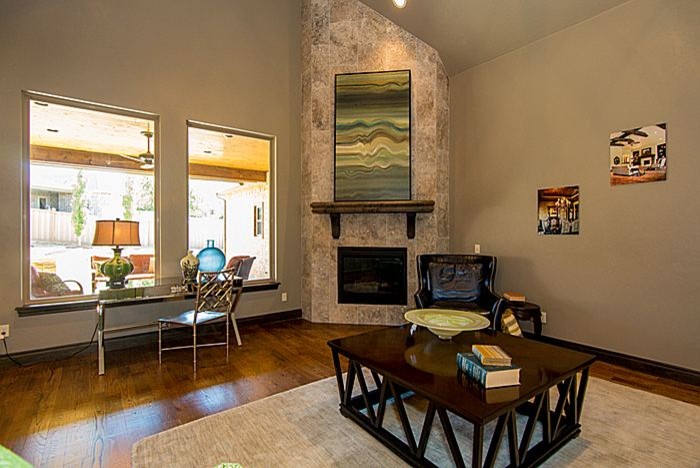 Cette image montre un grand salon design ouvert avec un mur beige, un sol en bois brun, une cheminée d'angle et un manteau de cheminée en carrelage.