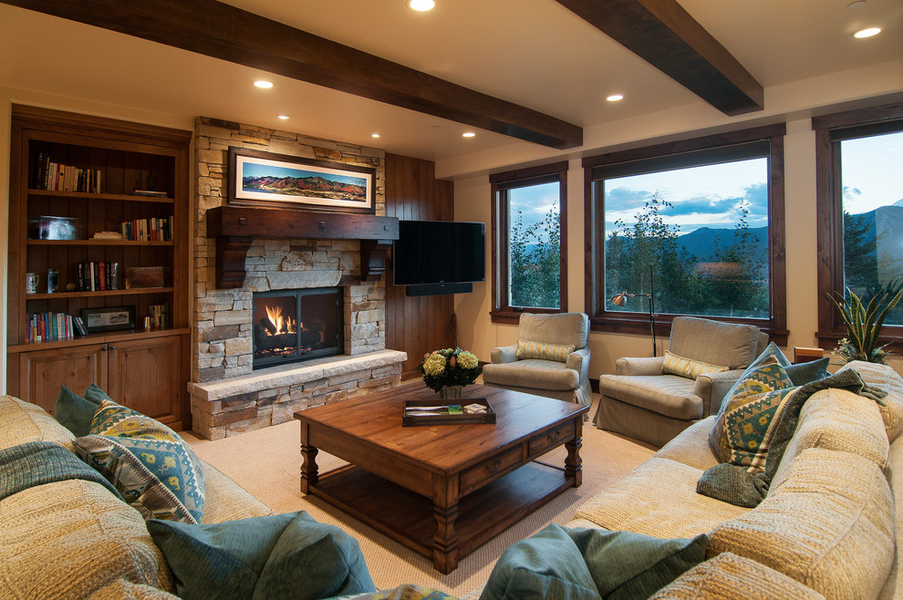 This is an example of a rustic living room in Salt Lake City with beige walls, carpet, a standard fireplace and a stone fireplace surround.
