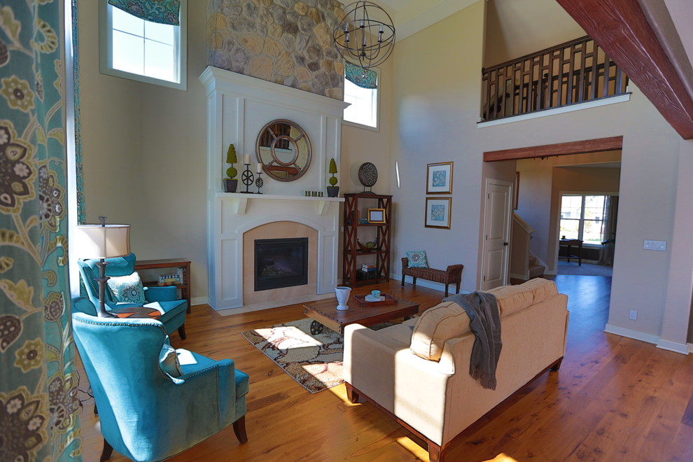 This is an example of a medium sized classic formal open plan living room in Milwaukee with beige walls, medium hardwood flooring, a standard fireplace, a tiled fireplace surround and no tv.