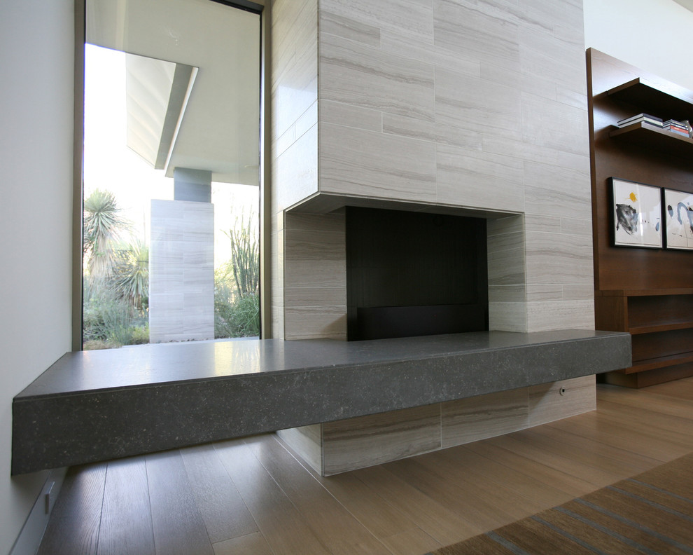 Свежая идея для дизайна: открытая гостиная комната с полом из известняка, стандартным камином и фасадом камина из камня - отличное фото интерьера