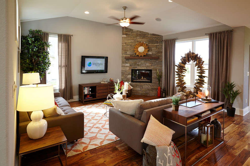 This is an example of a medium sized classic formal open plan living room in Milwaukee with beige walls, medium hardwood flooring, a corner fireplace, a stone fireplace surround and a wall mounted tv.