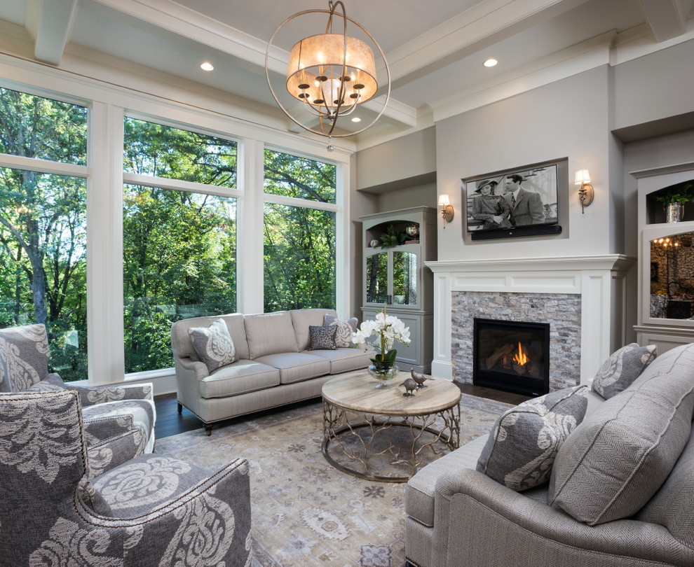 Inspiration for a large transitional formal and open concept dark wood floor and brown floor living room remodel in Minneapolis with gray walls, a standard fireplace, a stone fireplace and a wall-mounted tv