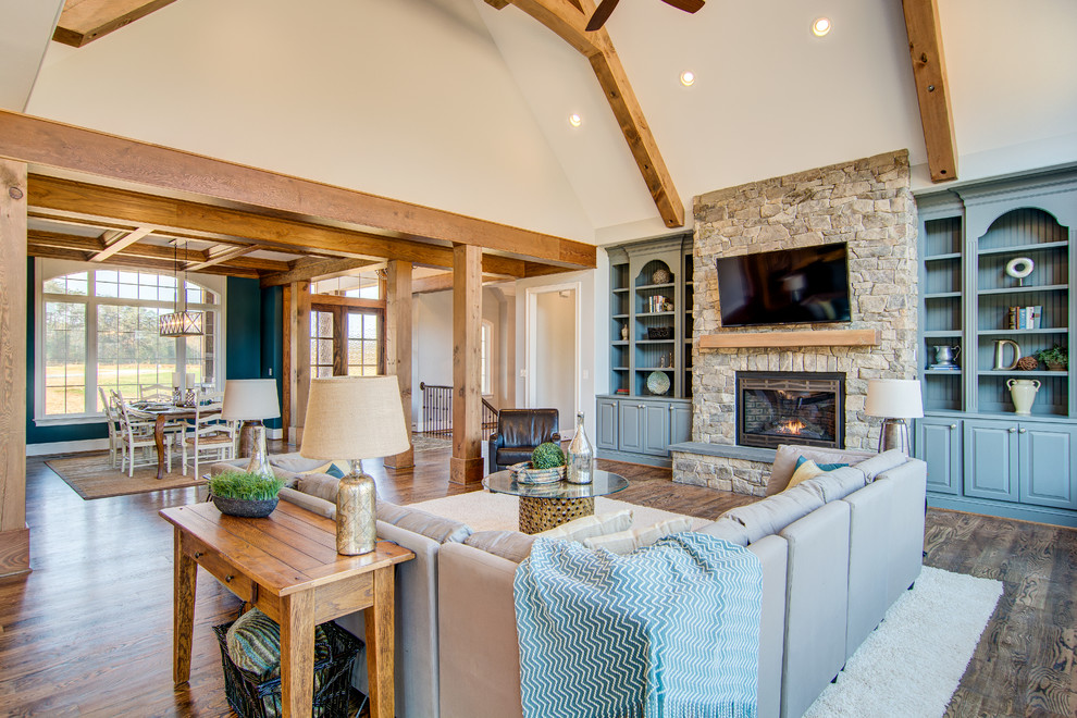 Inspiration for an expansive rustic open plan living room in Other with grey walls, medium hardwood flooring, a stone fireplace surround and a wall mounted tv.