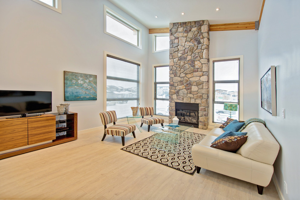 Стильный дизайн: большая открытая гостиная комната в стиле неоклассика (современная классика) с синими стенами, светлым паркетным полом, стандартным камином и фасадом камина из камня - последний тренд