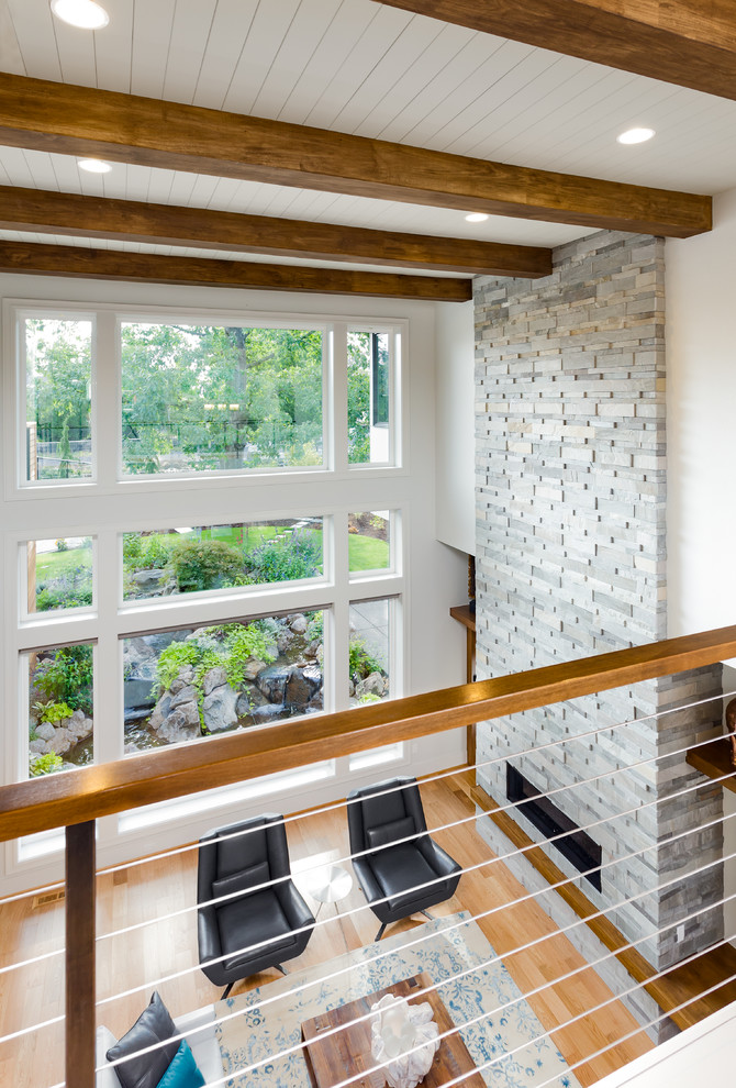 Geräumiges Modernes Wohnzimmer im Loft-Stil mit weißer Wandfarbe, hellem Holzboden, Kamin, Kaminumrandung aus Stein und TV-Wand in Portland