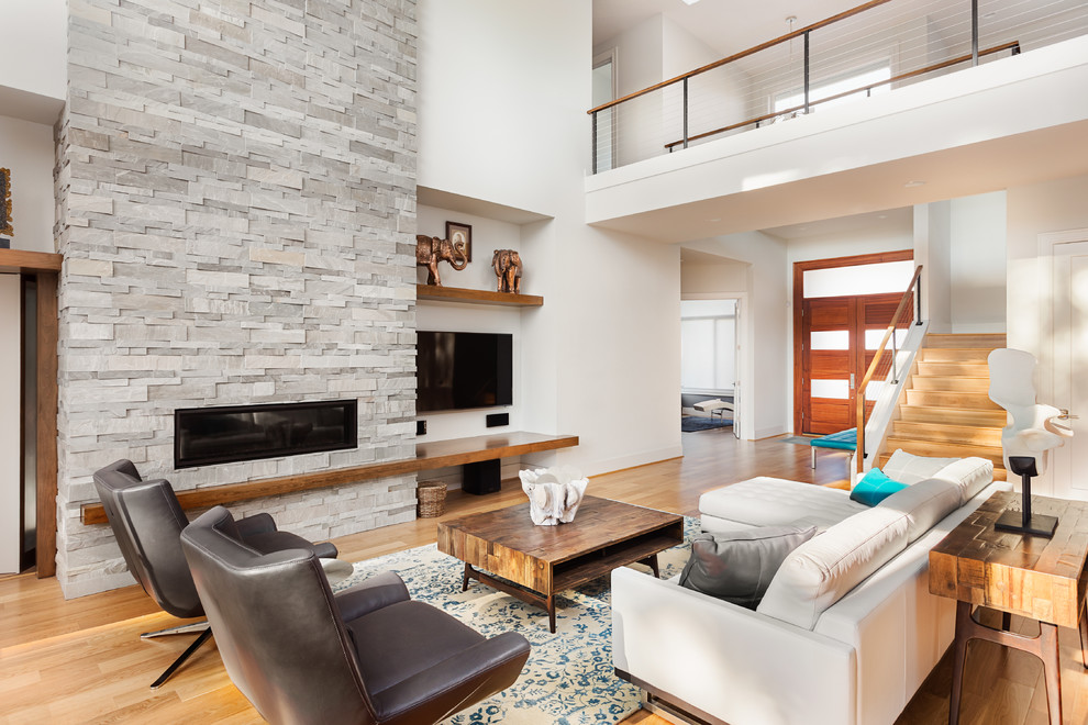 Geräumiges, Offenes Modernes Wohnzimmer mit weißer Wandfarbe, hellem Holzboden, Kamin, Kaminumrandung aus Stein und TV-Wand in Portland