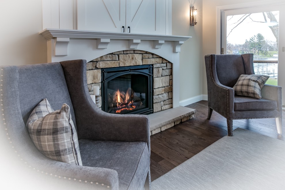 Example of a mid-sized transitional formal and open concept dark wood floor living room design in Minneapolis with beige walls, a standard fireplace, a stone fireplace and a concealed tv