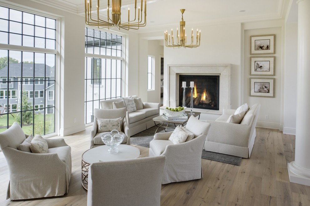 Repräsentatives Klassisches Wohnzimmer mit Kaminumrandung aus Stein, weißer Wandfarbe, hellem Holzboden und Kamin in Minneapolis