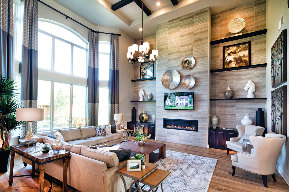 Example of a large classic open concept light wood floor living room design in Dallas with multicolored walls, a hanging fireplace, a tile fireplace and a wall-mounted tv