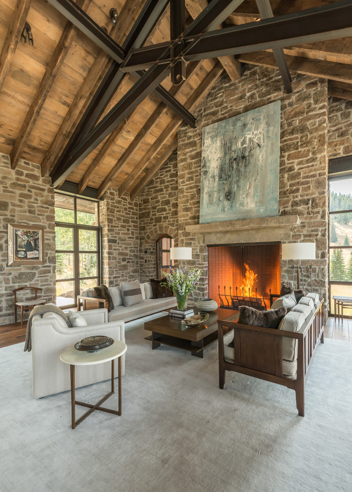 Photo of a medium sized rustic open plan living room in Other with a standard fireplace and a stone fireplace surround.