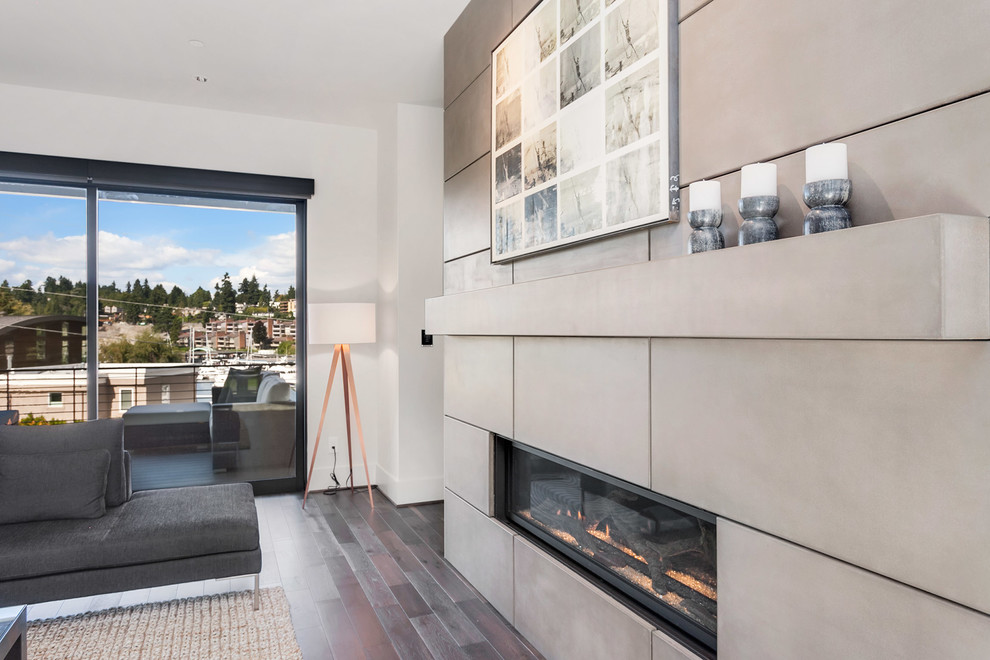 Inspiration for a large contemporary open plan living room in Seattle with grey walls, medium hardwood flooring, a standard fireplace, a concrete fireplace surround and brown floors.