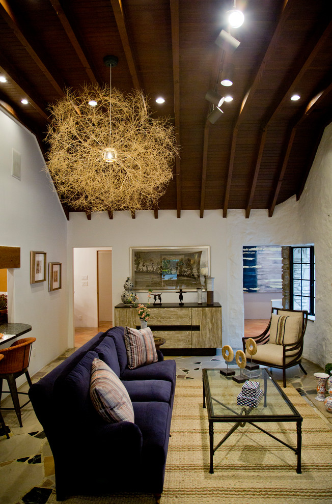 Стильный дизайн: большая парадная, изолированная гостиная комната в стиле фьюжн с белыми стенами, стандартным камином, фасадом камина из камня и разноцветным полом - последний тренд