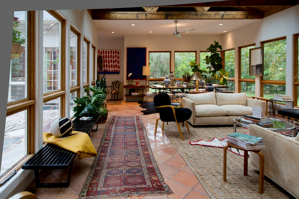 Example of a large eclectic enclosed terra-cotta tile and brown floor living room design in St Louis with white walls
