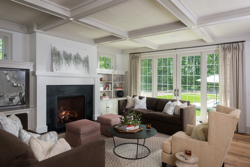 Design ideas for a medium sized rural enclosed living room in New York with a reading nook, white walls, light hardwood flooring, a standard fireplace, a stone fireplace surround, a built-in media unit and brown floors.