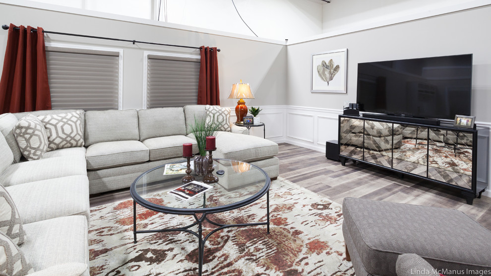 Ejemplo de salón abierto tradicional renovado de tamaño medio sin chimenea con paredes grises, suelo de madera clara, televisor independiente y suelo gris