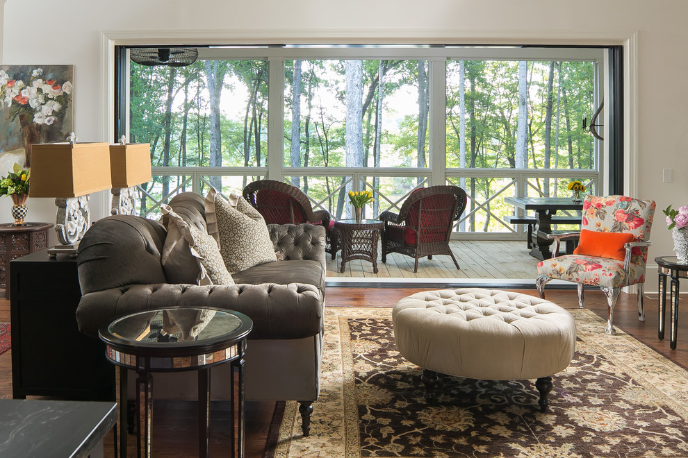 Exemple d'un grand salon nature ouvert avec un mur blanc, un sol en bois brun, une cheminée standard, un manteau de cheminée en brique et un téléviseur fixé au mur.