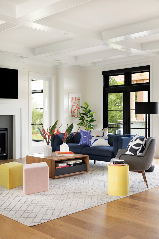 Cette image montre un grand salon design ouvert avec un mur blanc, une cheminée standard, un téléviseur fixé au mur, un plafond à caissons, un sol en bois brun et un sol marron.