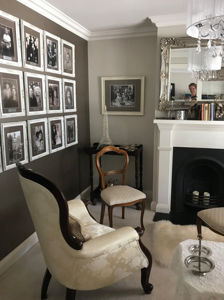 Bild på ett vintage vardagsrum, med ett finrum, beige väggar, heltäckningsmatta, en standard öppen spis, en spiselkrans i gips och vitt golv