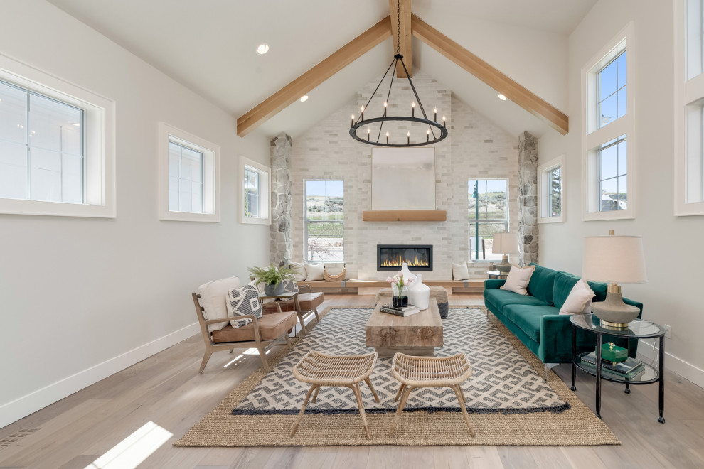 Design ideas for a large farmhouse open plan living room in Boise with grey walls, light hardwood flooring, a standard fireplace, a stone fireplace surround, no tv and beige floors.