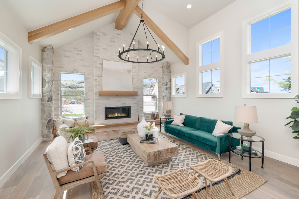 Inspiration for a large cottage open concept light wood floor and beige floor living room remodel in Boise with gray walls, a standard fireplace, a stone fireplace and no tv