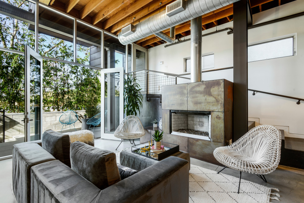 Imagen de salón para visitas abierto urbano sin televisor con paredes blancas, suelo de cemento, chimenea lineal y marco de chimenea de metal