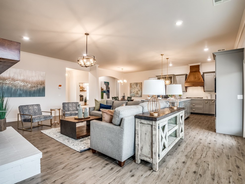 Großes, Offenes Country Wohnzimmer mit weißer Wandfarbe, hellem Holzboden, Kamin und Kaminumrandung aus Backstein in Oklahoma City