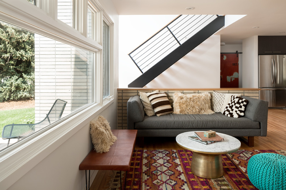 Immagine di un soggiorno contemporaneo con pareti bianche, pavimento in legno massello medio e pavimento marrone