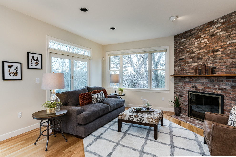 Example of a mid-sized transitional formal and enclosed light wood floor and brown floor living room design in Boston with white walls, a corner fireplace, a brick fireplace and no tv