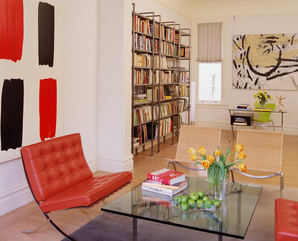 Immagine di un soggiorno contemporaneo con libreria, pareti bianche, parquet chiaro e pavimento marrone