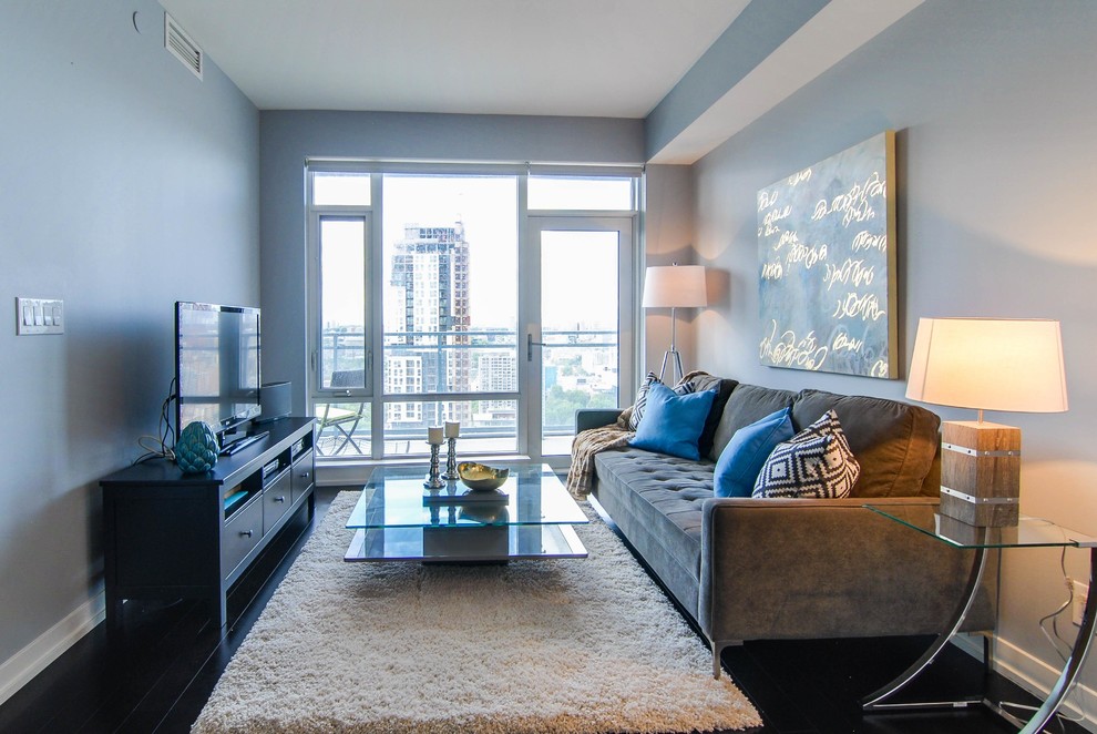 Example of a small minimalist open concept dark wood floor living room design in Toronto with blue walls, no fireplace and a tv stand