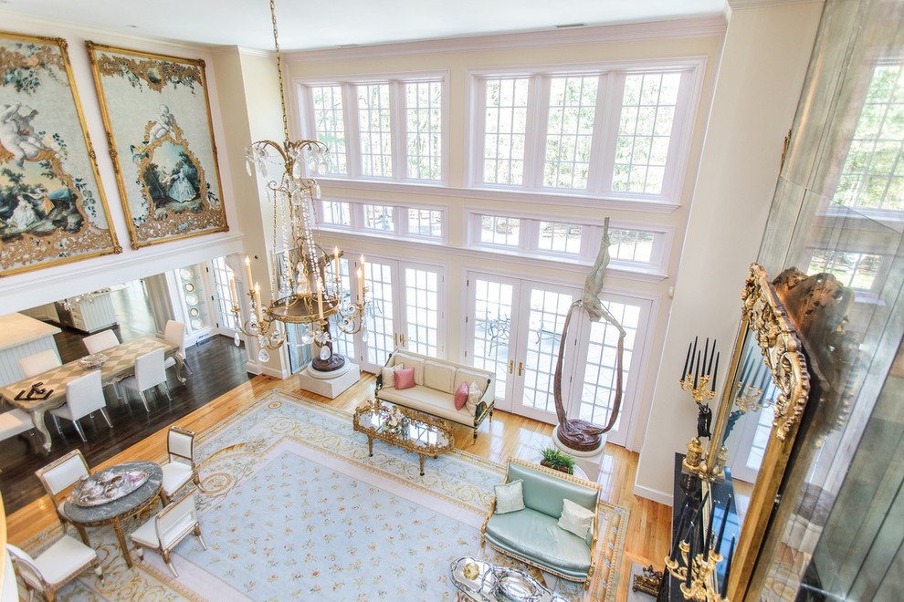 Стильный дизайн: огромная парадная, изолированная гостиная комната в классическом стиле с синими стенами, паркетным полом среднего тона, стандартным камином, фасадом камина из дерева и разноцветным полом - последний тренд