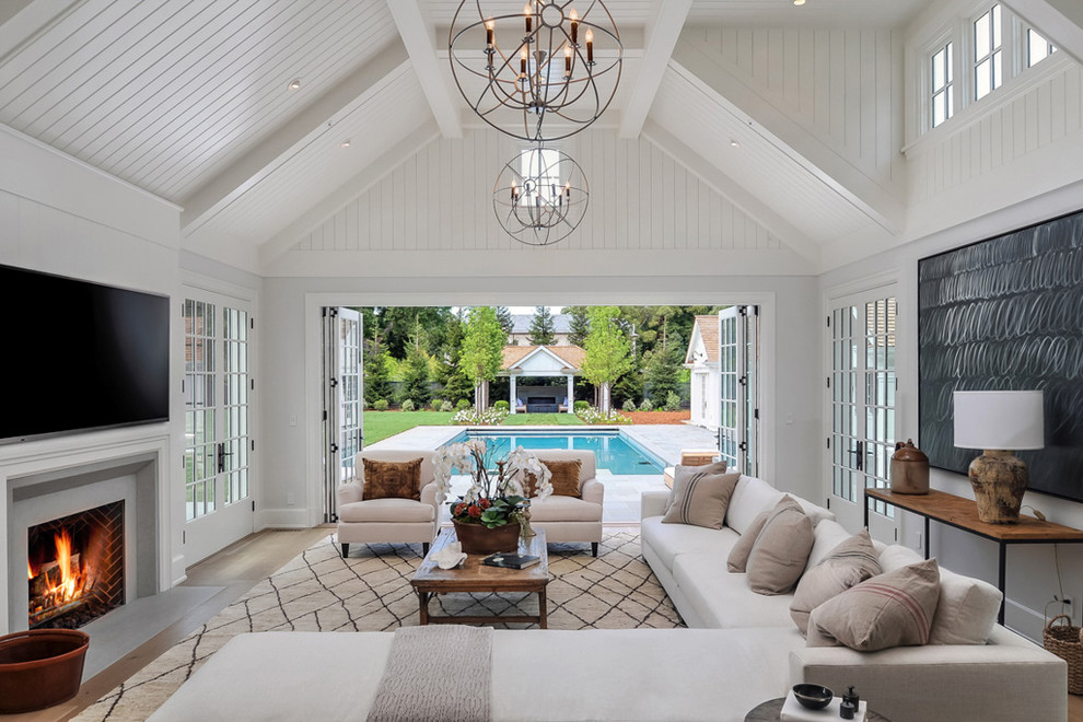 Farmhouse medium tone wood floor living room photo in San Francisco with white walls, a standard fireplace and a wall-mounted tv