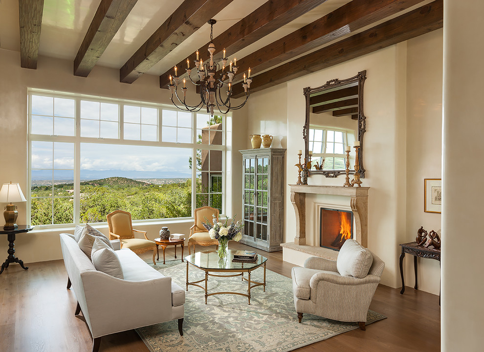 Immagine di un soggiorno american style aperto con sala formale, pareti beige, pavimento in legno massello medio, camino classico e tappeto