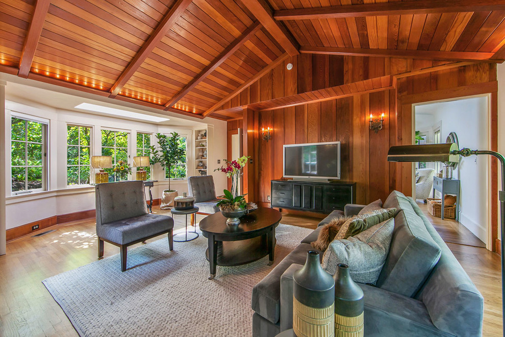Imagen de salón cerrado clásico con suelo de madera en tonos medios y televisor independiente