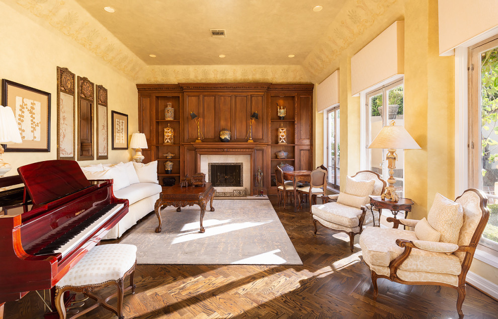 This is an example of a rustic formal living room in Orange County with dark hardwood flooring, a standard fireplace, a wooden fireplace surround and brown floors.