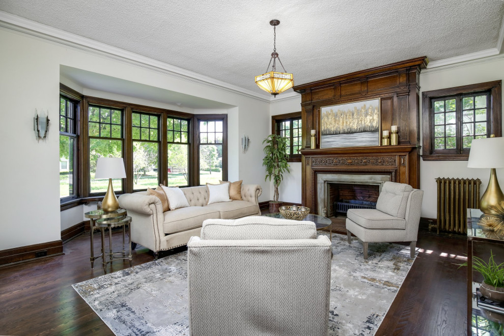 Example of a classic enclosed dark wood floor and brown floor living room design in Detroit with white walls and a standard fireplace